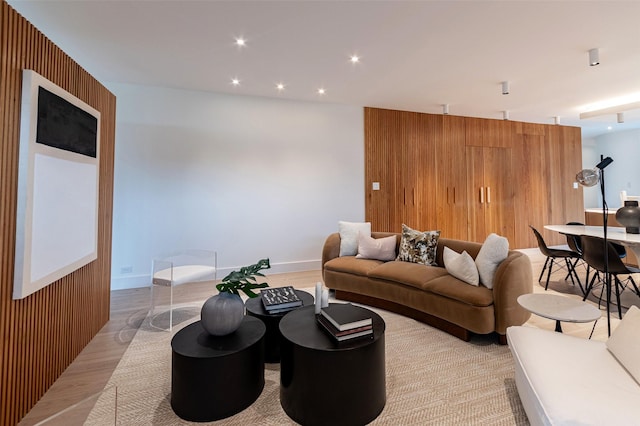 living room with light wood-type flooring and wooden walls