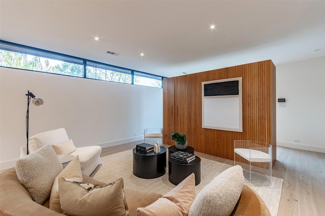 living room featuring wooden walls and light hardwood / wood-style flooring