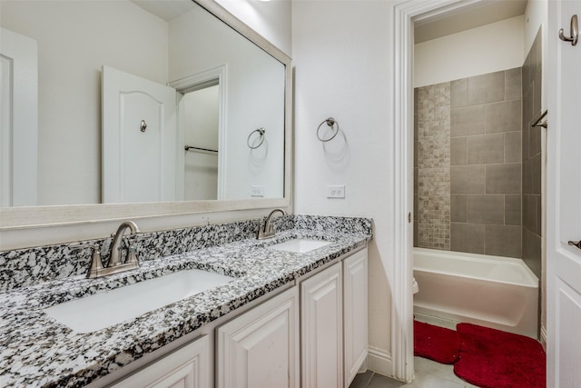 full bathroom featuring tile patterned floors, vanity, toilet, and tiled shower / bath combo