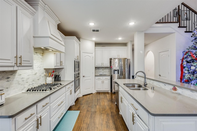 kitchen featuring premium range hood, stainless steel appliances, sink, dark hardwood / wood-style floors, and white cabinetry