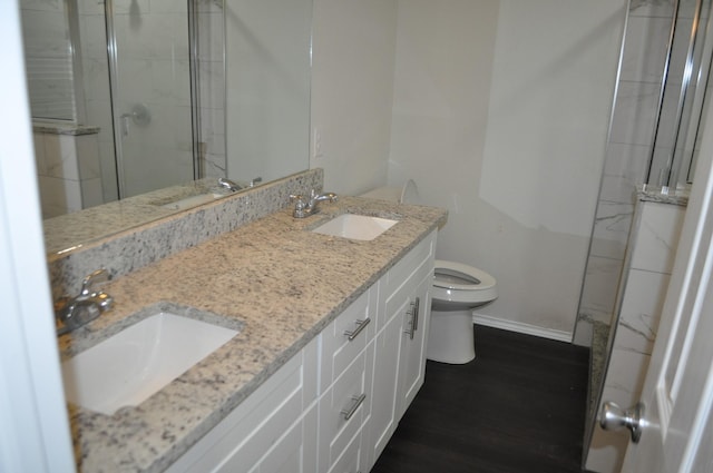 bathroom with walk in shower, hardwood / wood-style floors, vanity, and toilet