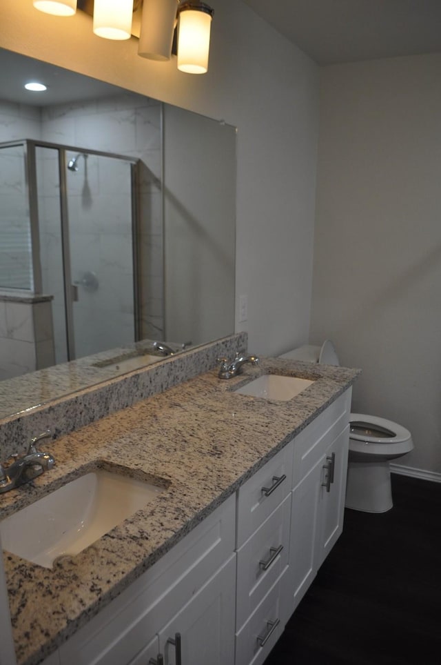 bathroom with an enclosed shower, vanity, and toilet