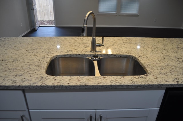 room details featuring light stone counters and sink