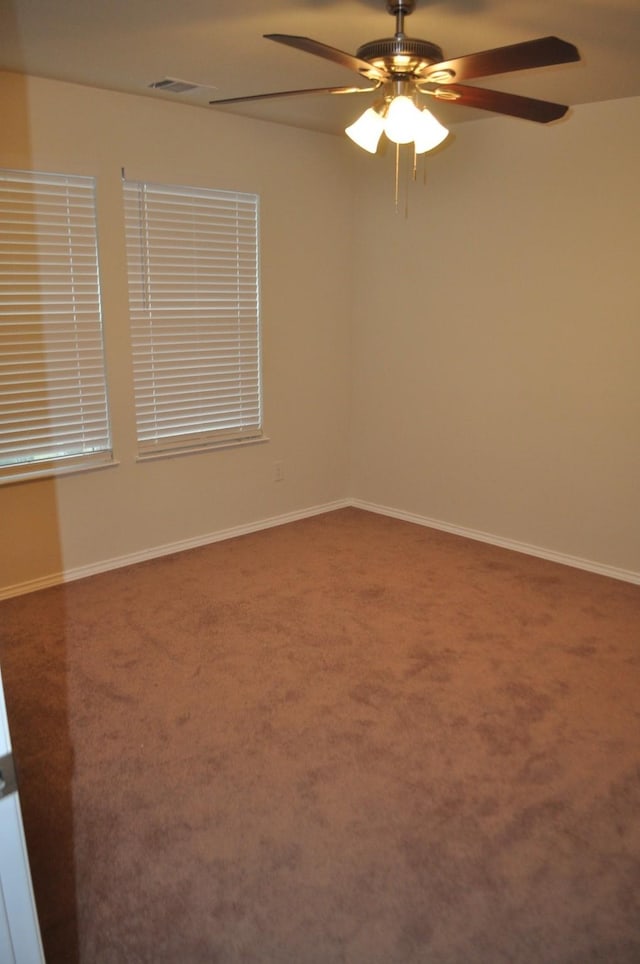 carpeted spare room with ceiling fan