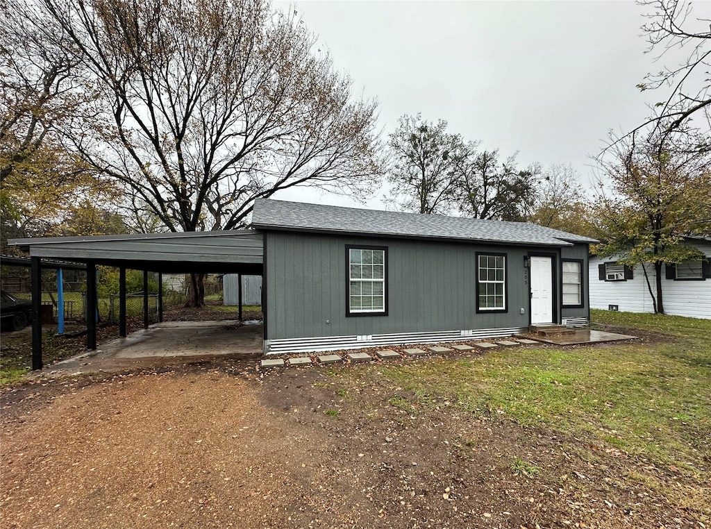 view of front facade with a front lawn and a carport