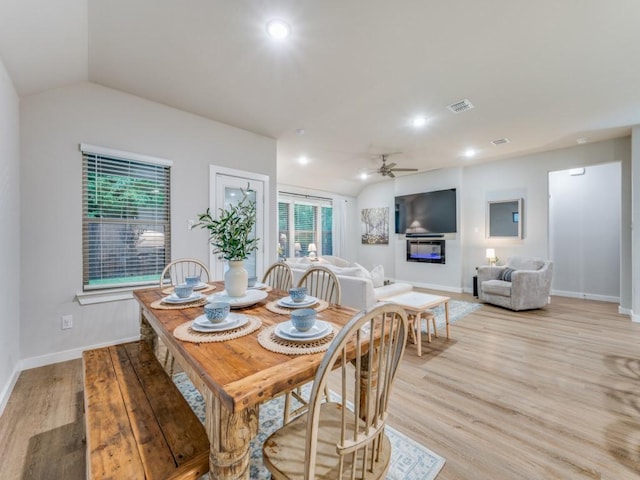 dining room featuring ceiling fan, light hardwood / wood-style floors, and lofted ceiling