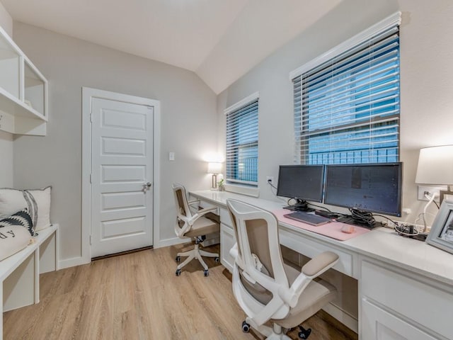 home office featuring light wood-type flooring and vaulted ceiling