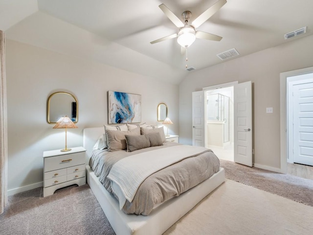 bedroom featuring ceiling fan, carpet, ensuite bathroom, and lofted ceiling