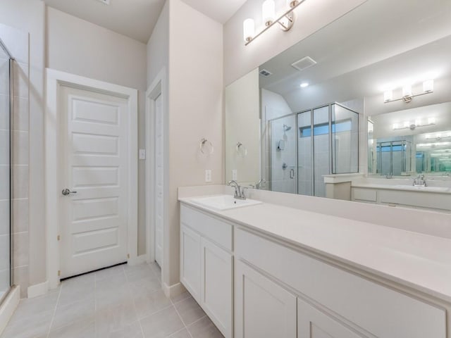 bathroom featuring vanity, tile patterned floors, and a shower with door