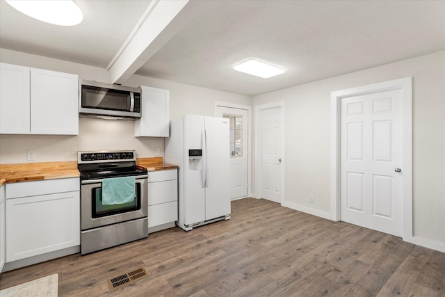 kitchen with light hardwood / wood-style flooring, white cabinets, wooden counters, and appliances with stainless steel finishes