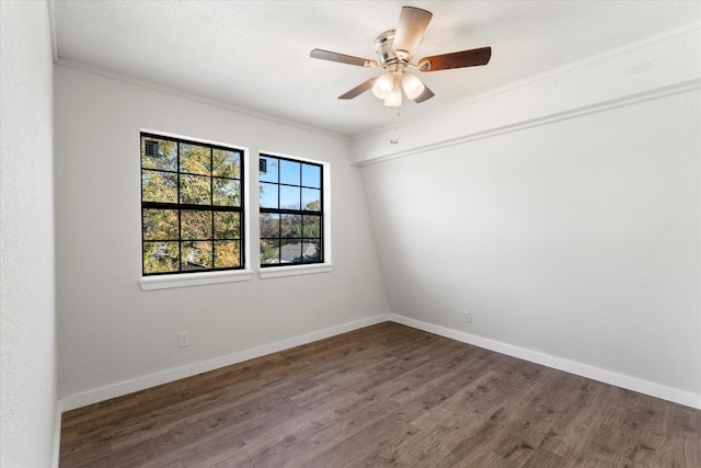 spare room featuring ornamental molding, ceiling fan, and dark wood-type flooring