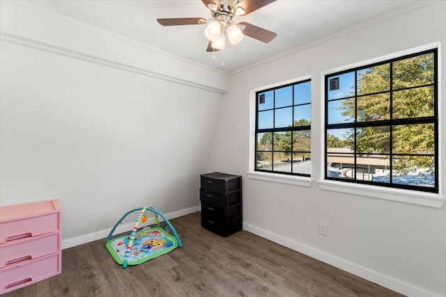 game room featuring dark hardwood / wood-style floors, ceiling fan, and crown molding