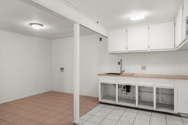 laundry area featuring light tile patterned flooring and sink