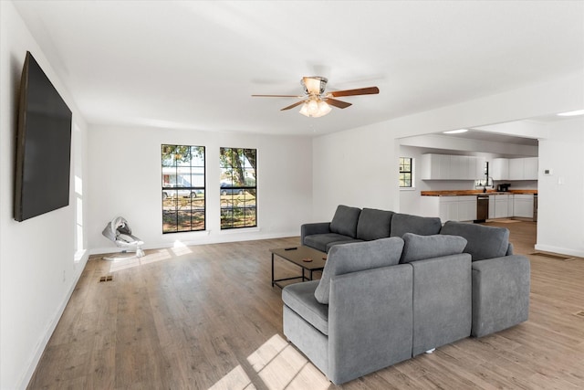 living room featuring ceiling fan and light hardwood / wood-style floors