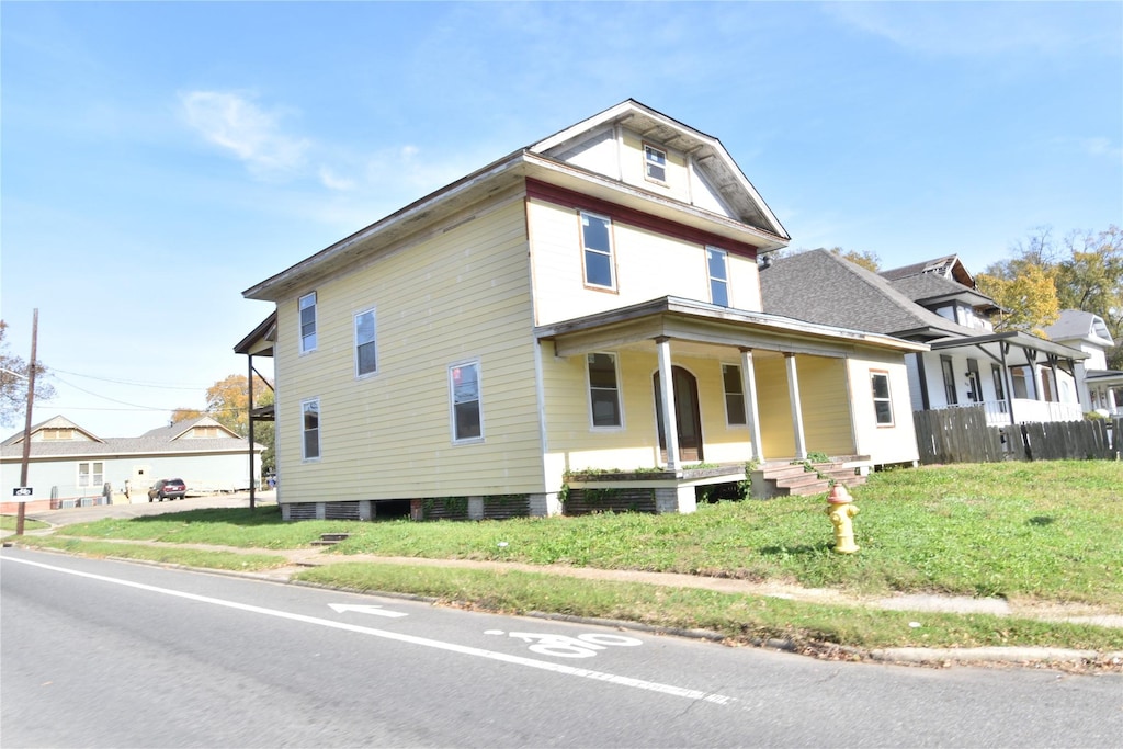 view of front facade featuring covered porch and a front lawn