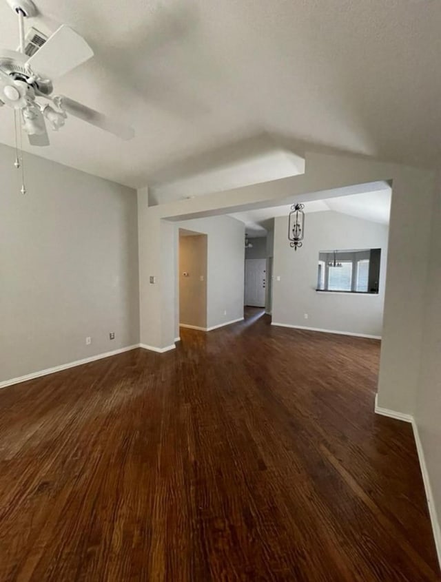 unfurnished living room with dark hardwood / wood-style floors, ceiling fan, and vaulted ceiling