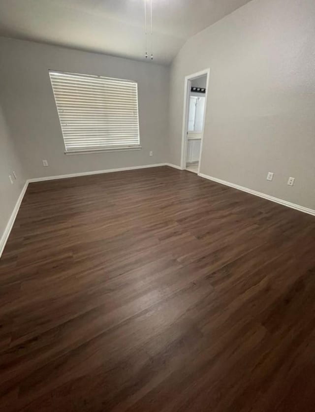 empty room featuring dark hardwood / wood-style flooring and lofted ceiling