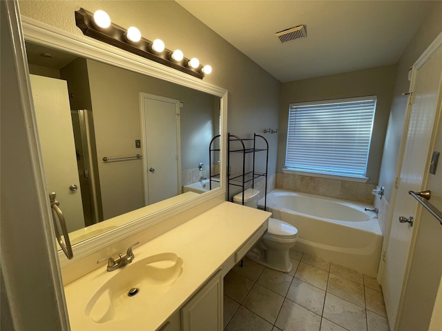 bathroom with tile patterned flooring, vanity, toilet, and a tub