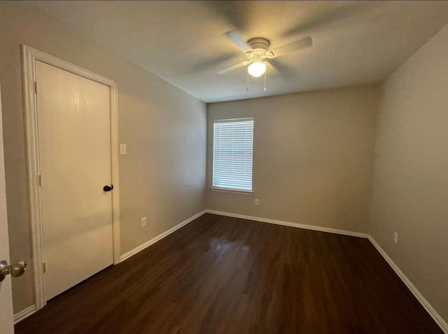 empty room featuring dark hardwood / wood-style flooring and ceiling fan