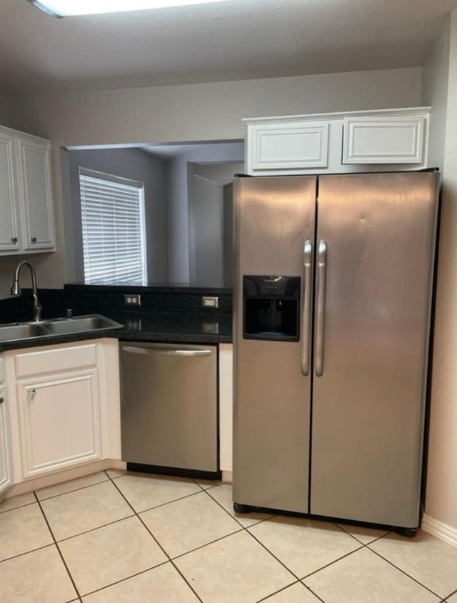 kitchen featuring sink, white cabinets, light tile patterned flooring, and appliances with stainless steel finishes