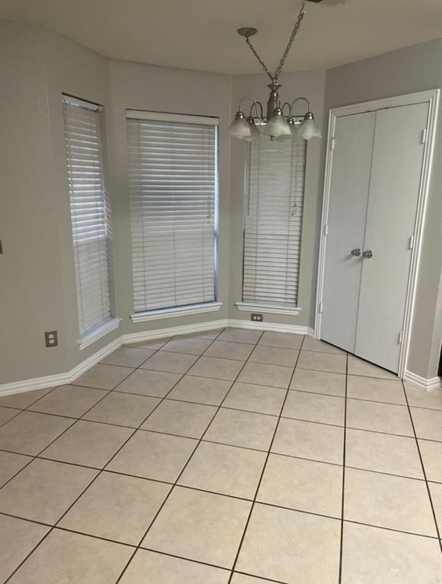 unfurnished dining area featuring a notable chandelier and light tile patterned floors