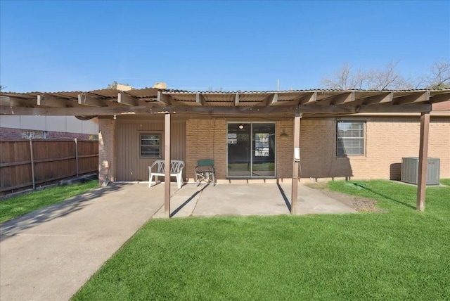 rear view of property with central AC, a patio area, and a lawn