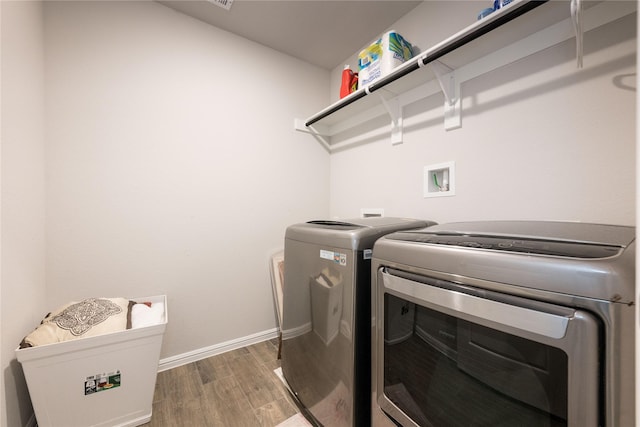 laundry area with hardwood / wood-style flooring and washing machine and dryer