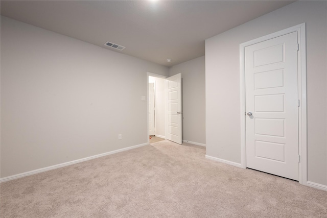 unfurnished bedroom featuring baseboards, visible vents, and light colored carpet