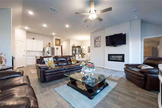 living room with hardwood / wood-style flooring, vaulted ceiling, and ceiling fan