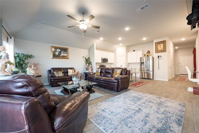 living room featuring ceiling fan, light hardwood / wood-style flooring, and lofted ceiling