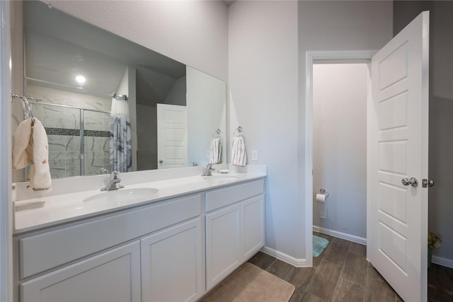 bathroom featuring a shower with door, vanity, and hardwood / wood-style flooring