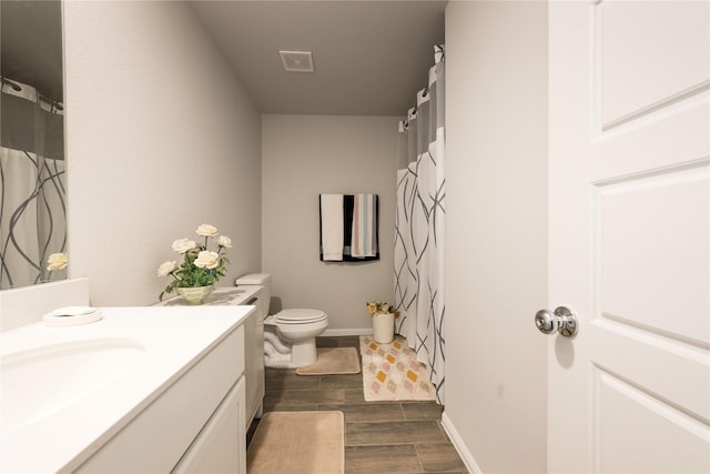 bathroom with vanity, hardwood / wood-style flooring, and toilet