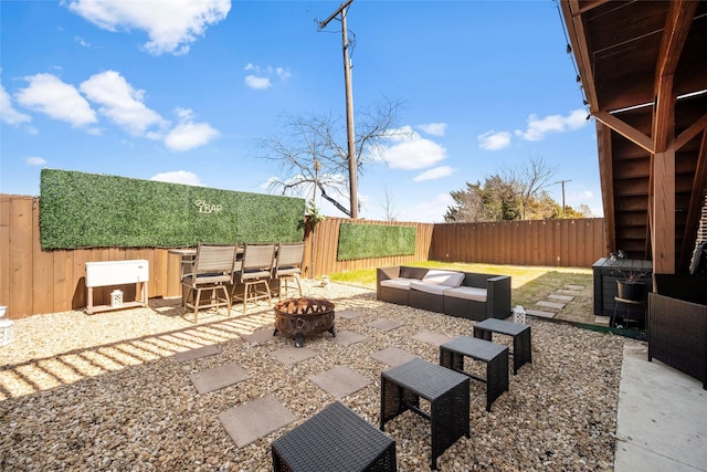 view of patio with an outdoor living space with a fire pit