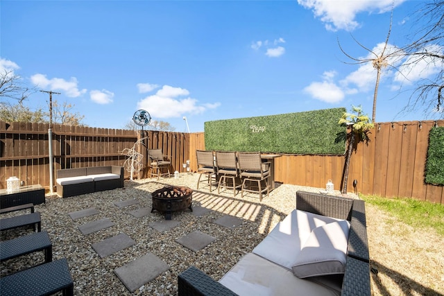 view of patio with an outdoor living space with a fire pit