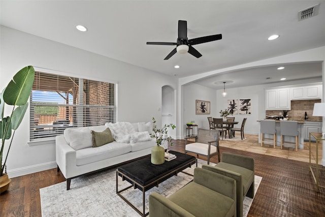 living room featuring wood-type flooring and ceiling fan