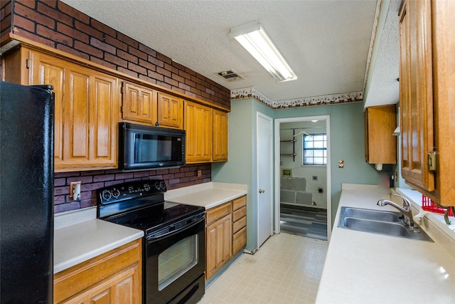 kitchen with sink, a textured ceiling, and black appliances