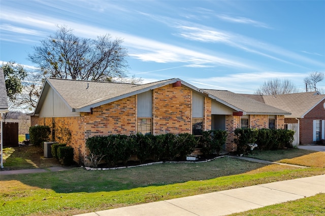 view of front of property with central air condition unit and a front lawn