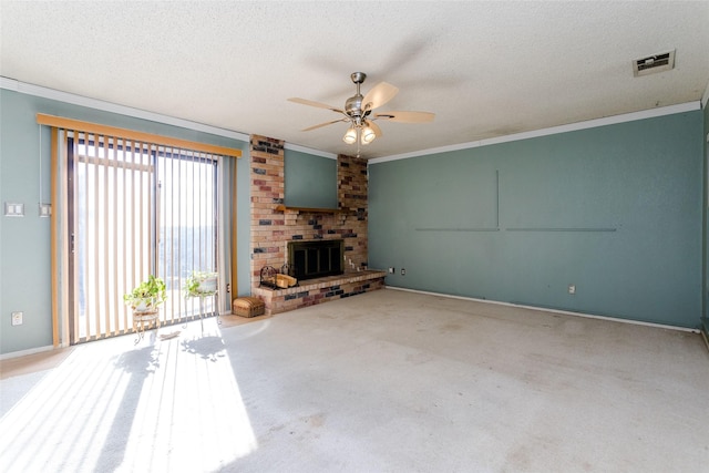 unfurnished living room with crown molding, a brick fireplace, a textured ceiling, carpet floors, and ceiling fan