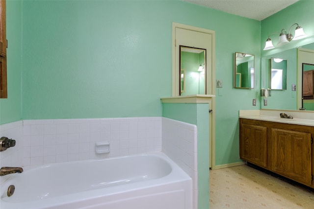 bathroom with vanity, a textured ceiling, and a bathtub