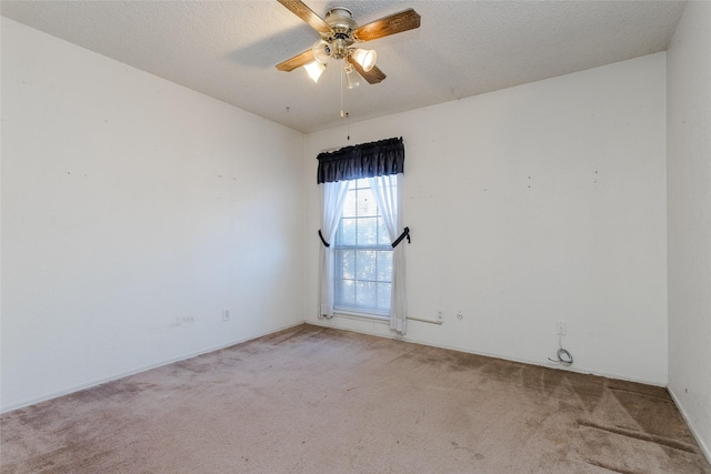 carpeted spare room featuring ceiling fan and a textured ceiling