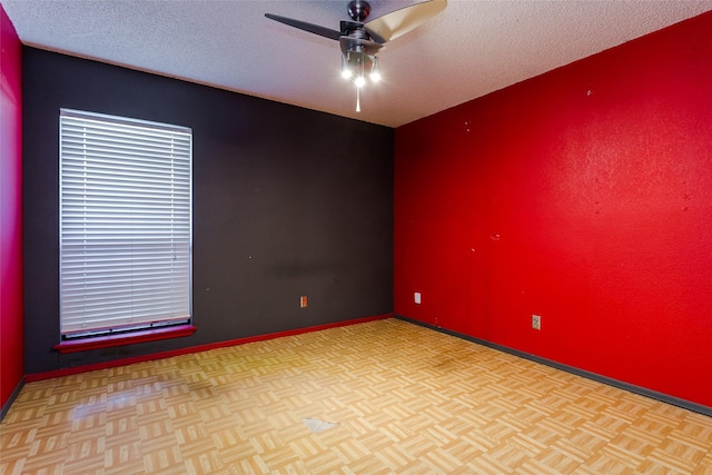 spare room with ceiling fan, light parquet flooring, and a textured ceiling