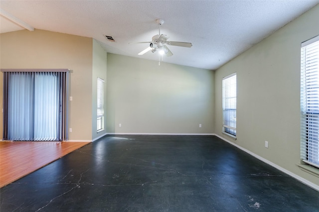 empty room featuring ceiling fan, a textured ceiling, and vaulted ceiling with beams