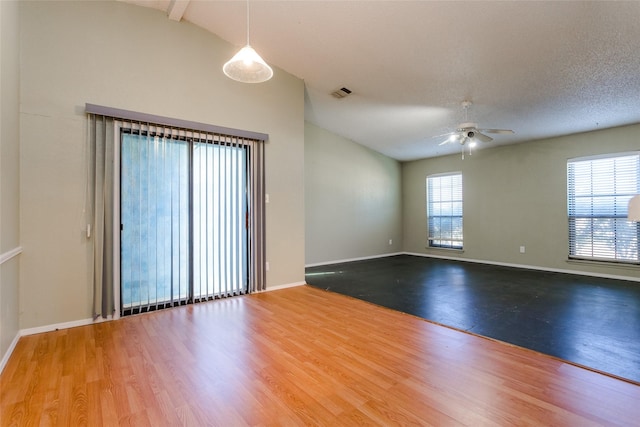 spare room featuring ceiling fan, wood-type flooring, a textured ceiling, and vaulted ceiling with beams