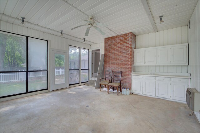 unfurnished living room featuring dark hardwood / wood-style floors, ceiling fan, a fireplace, and a wealth of natural light