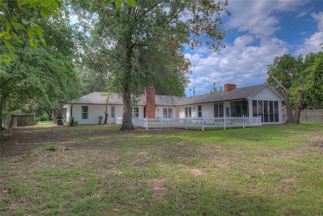 view of front of property featuring a sunroom and a front lawn