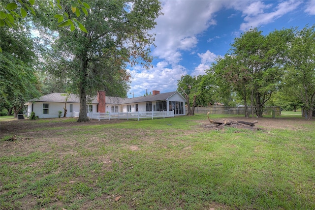 view of yard with a sunroom and fence