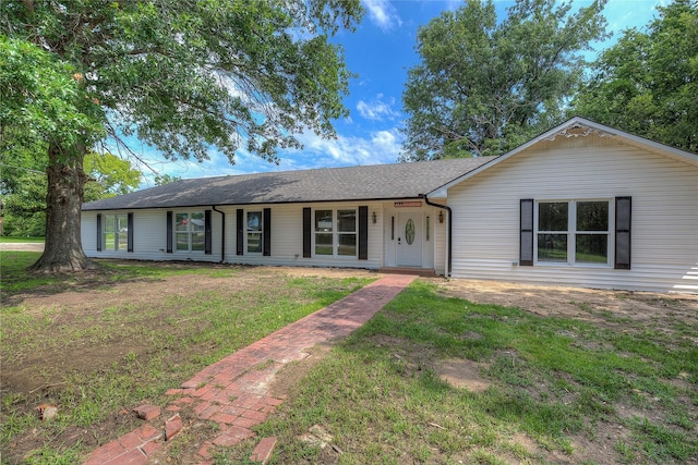 ranch-style home featuring a front yard and a shingled roof