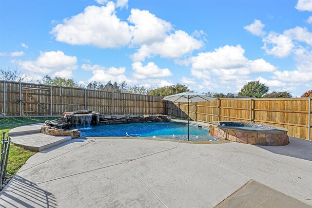 view of pool featuring an in ground hot tub, pool water feature, and a patio