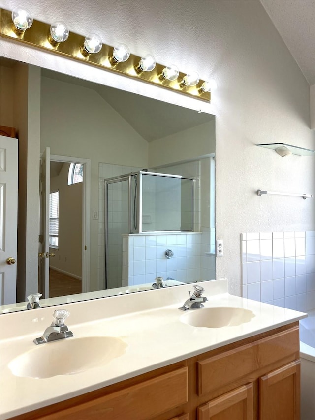 bathroom featuring vanity, vaulted ceiling, and separate shower and tub