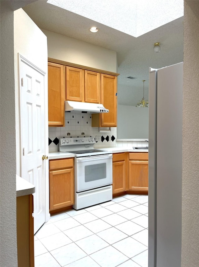 kitchen featuring sink, refrigerator, light tile patterned floors, backsplash, and electric stove